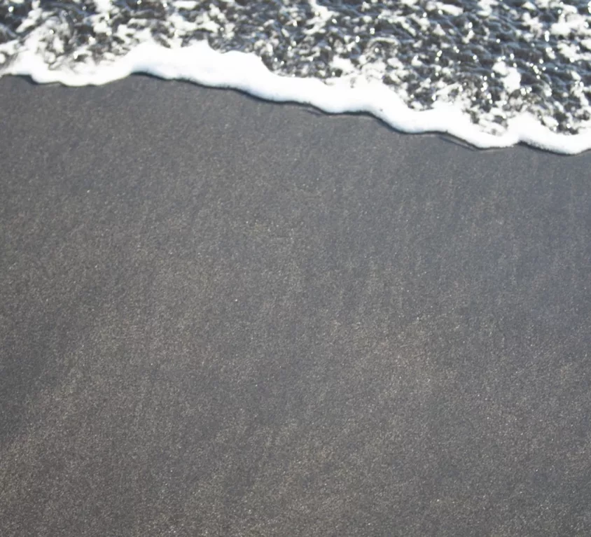 A black sand beach in Iceland with a calm tide
